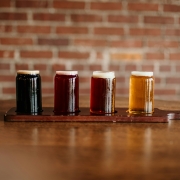 a flight of draft beers against a brick wall