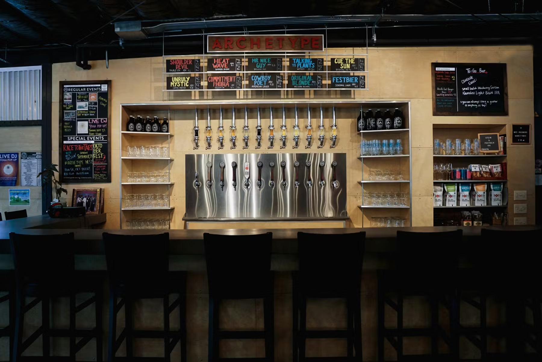 A bar with a row of beer taps and shelves with glasses and bottles.