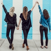 three women facing a striped wall
