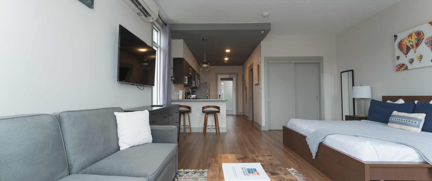 Living area, kitchen, and king bed in a River Row suite in Asheville's River Arts District